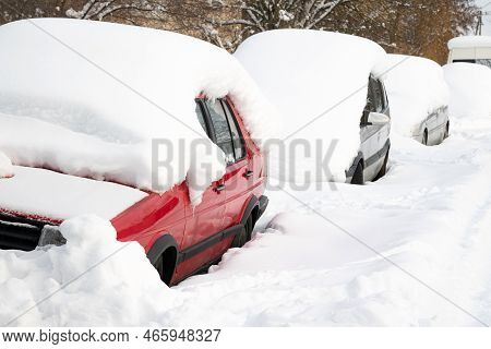 Car Under Thick Blanket Of Snow After Storm. Vehicles Buried Under Ice. Nobody