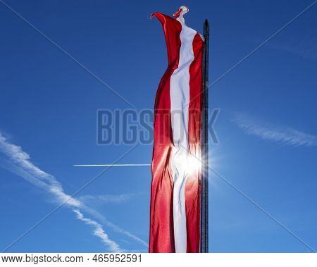 Bright Red-white-red Flag Of Austria Against A Clear Sky On A Sunny Day
