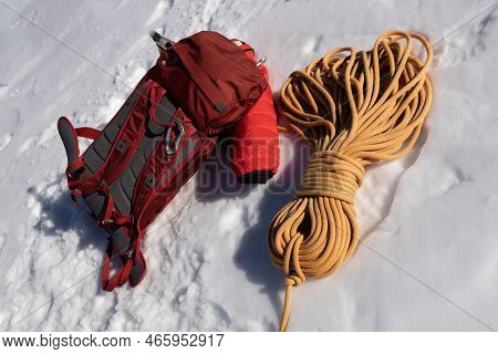Red Backpack And Yellow Rope Lie On A Snowy Slope, Austria, Alps, Dachstein