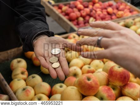 A Woman Buys Apples And Pays With Cash Coins For Purchases At An Open Food Market, Austria, Salzburg