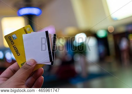 Man Holding A Credit Card With Two Tickets To The Cinema. Buy Online With A Debit Or Credit Card. Ci