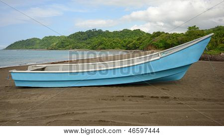 Barco azul na praia perto de Ocean Will Tropical Rainforest