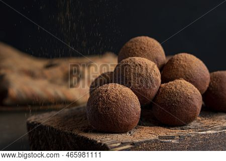 Pouring Cocoa Powder On Enegry Balls. Homemade Healthy Vegan Raw Energy Truffle Balls With On Wooden