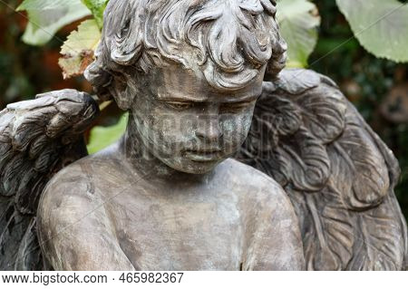 Small Putto With Angel Wings On A Grave Looks Sadly To The Ground