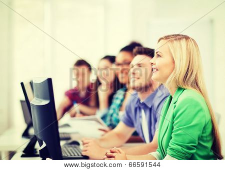 education concept - students with computers studying at school