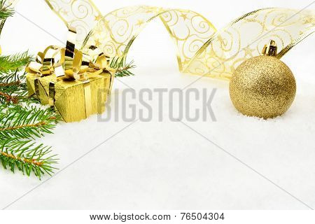 Golden Christmas Baubles With And Needles Fir And Ribbon On Snow