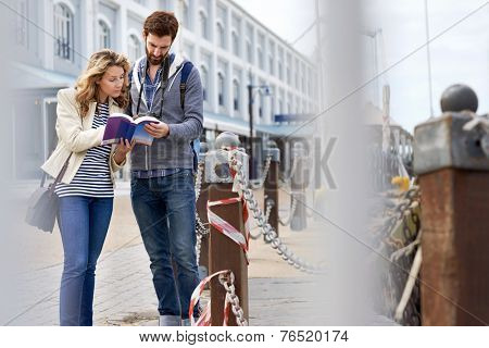 tourist couple with guide book on vacation
