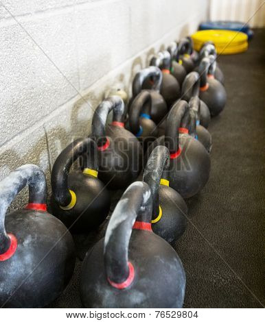 Kettlebells arranged in a row at cross fitness box