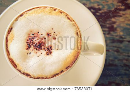 Cappuccino or latte coffee on table with retro filter effect
