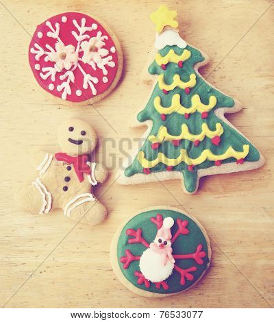 Decorated christmas gingerbreads on wooden background with retro filter effect