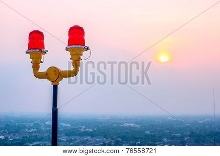 Dual red light on top of building against dawn sun light