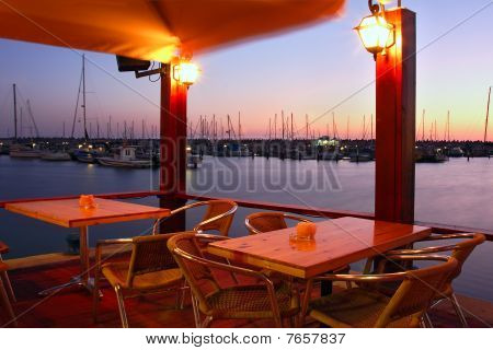 Outdoor Restaurant On Marina At Evening.