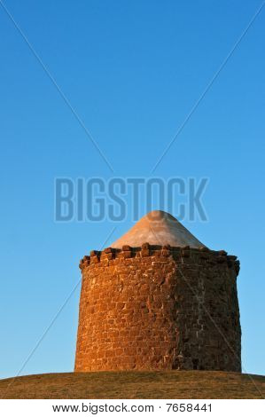 Sten Monument på en bakketop ved solnedgang