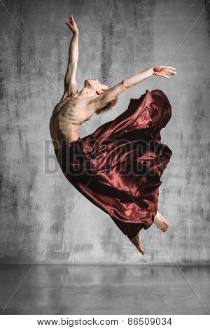 young beautiful modern style dancer posing on a studio background