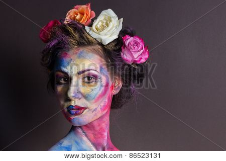 Model with colorful make-up and roses in hair.