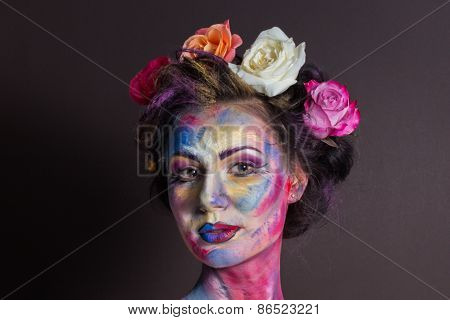 Model with colorful make-up and roses in hair.