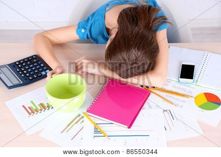 Beautiful girl slipping at table with large cup 