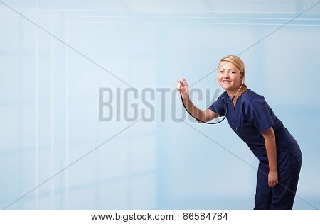 Pretty young nurse in hospital listening to empty copy space with sthetoscope