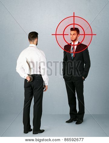 Ruthless businessman handshake with a hiding weapon and a head target point