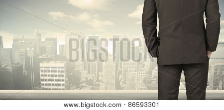 Businessman from the back in front of a city view on the window