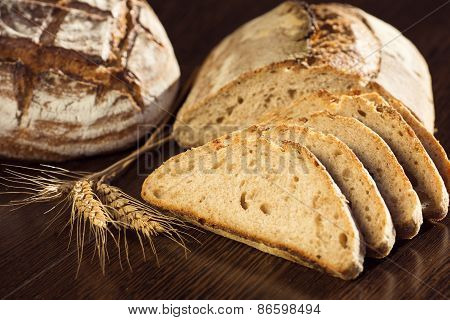 Rustic Bread And Wheat On A Dark Brown Fundal