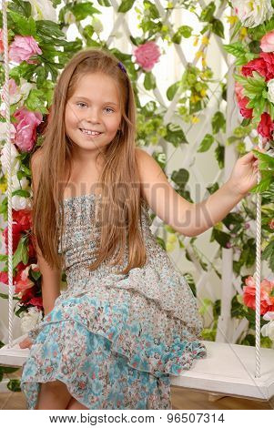 Girl Sits On A Swing In An Flower Arbor