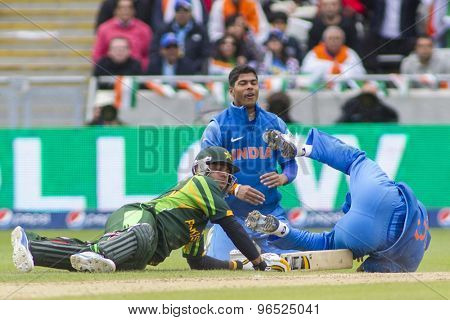 EDGBASTON, ENGLAND - June 15 2013: Pakistan's Mohammad Hafeez and India's Mahendra Singh Dhoni  during the ICC Champions Trophy cricket match between India and Pakistan at Edgbaston Cricket Ground.