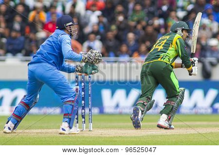 EDGBASTON, ENGLAND - June 15 2013: India's Mahendra Singh Dhoni and Pakistan's Umar Amin during the ICC Champions Trophy cricket match between India and Pakistan at Edgbaston Cricket Ground.