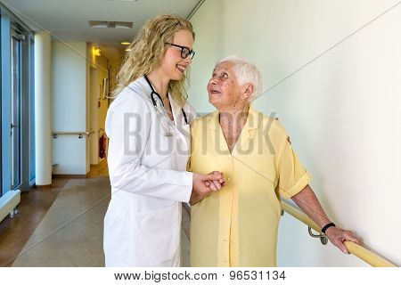 Medical Assistant Assisting Elderly In Hospital