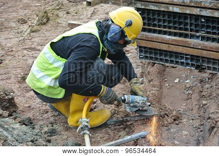 Construction workers using construction grinder to sharpen steel at construction site
