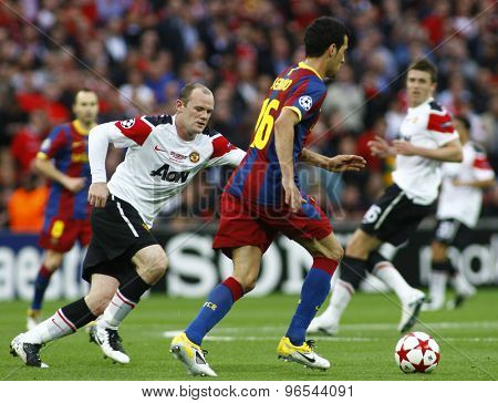 LONDON, ENGLAND. May 28 2011: Manchester's forward Wayne Rooney and Barcelona's midfielder Sergio Busquets during the 2011 UEFA Champions League final between Manchester United and FC Barcelona