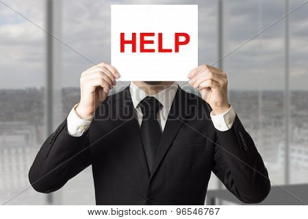 Businessman Hiding Face Behind Sign Help