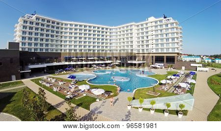 RUSSIA, SOCHI - JUL 25, 2014: People swim in pool of hotel Radisson Blu at summer sunny day. Aerial view. Photo with noise from action camera.