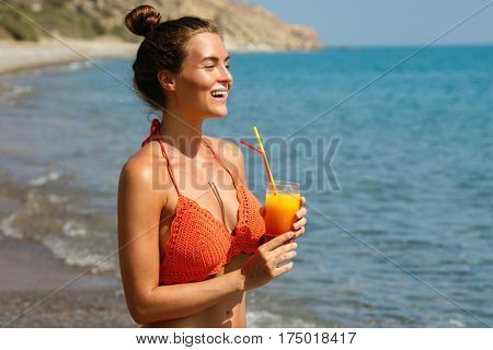 Beautiful woman on the beach with a glass of cocktail
