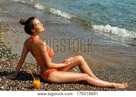 Beautiful woman on the beach with a glass of cocktail