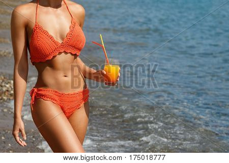 Beautiful woman on the beach with a glass of cocktail