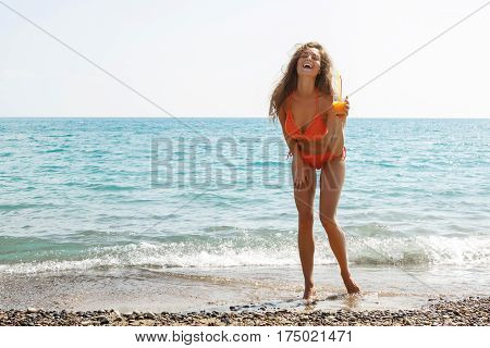 Beautiful woman on the beach with a glass of cocktail