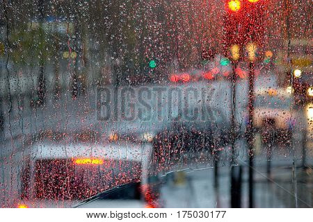 London rain view to red bus through rain-specked window