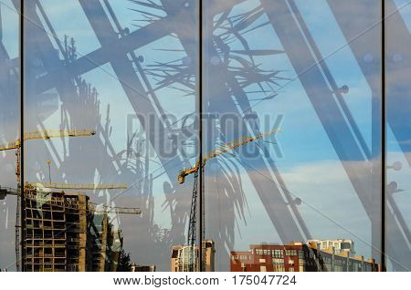 Construction site in the reflection of the glass facade of a modern building. Abstract background