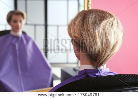 Young woman with trendy hairstyle at beauty salon