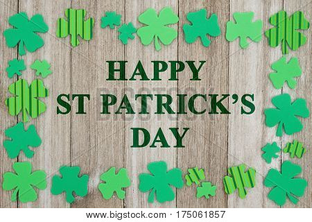 Saint Patrick's Day greeting Green shamrocks on weathered wood with text Happy Saint Patrick's Day