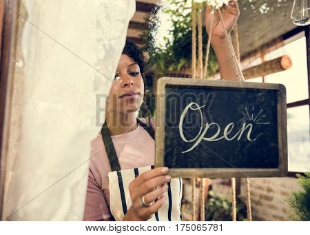 Woman Hanging Open Sign by the Glass Window