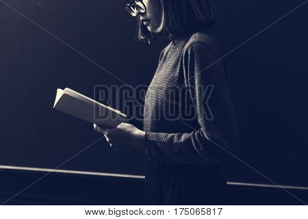 Girl with Glasses Standing Reading Book