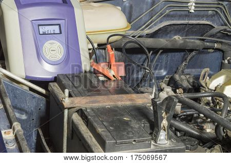 Battery charger charging the battery of an old vehicle