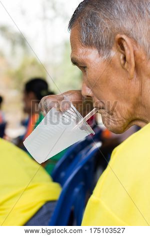 CHIANG RAI THAILAND - FEBRUARY 20 : unidentified man suffering from leprosy drinking water on February 20 2016 in Chiang rai Thailand.