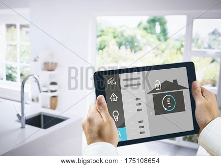 Digital composite image of hands holding digital tablet with home security icons
