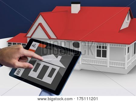 Digital composite image of hands using digital tablet with home security icons