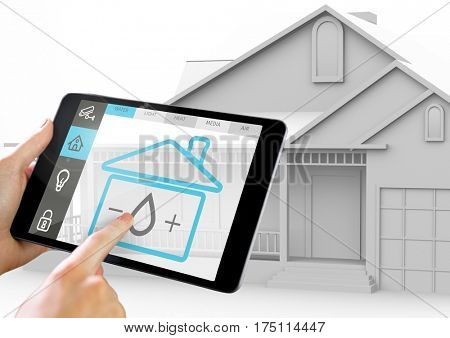 Hand holding digital tablet with home security icons on screen against home