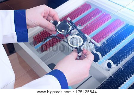 Close-up of optometrist holding messbrille glasses in ophthalmology clinic. Ophthalmic glasses for diopter detection.