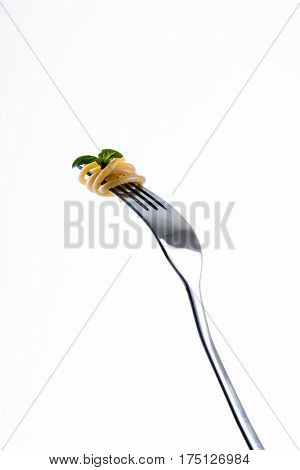 Pasta on fork tines, garnished with basil leaf